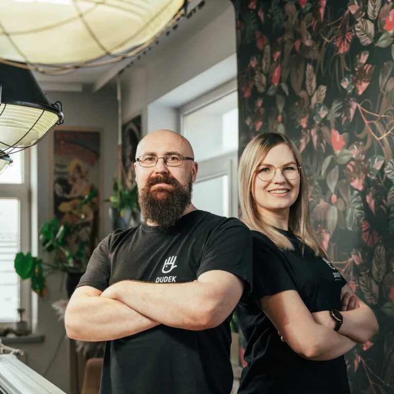 Michał Dudek z zespołem Dudek Manufaktura na tle tapety w ciemne liście