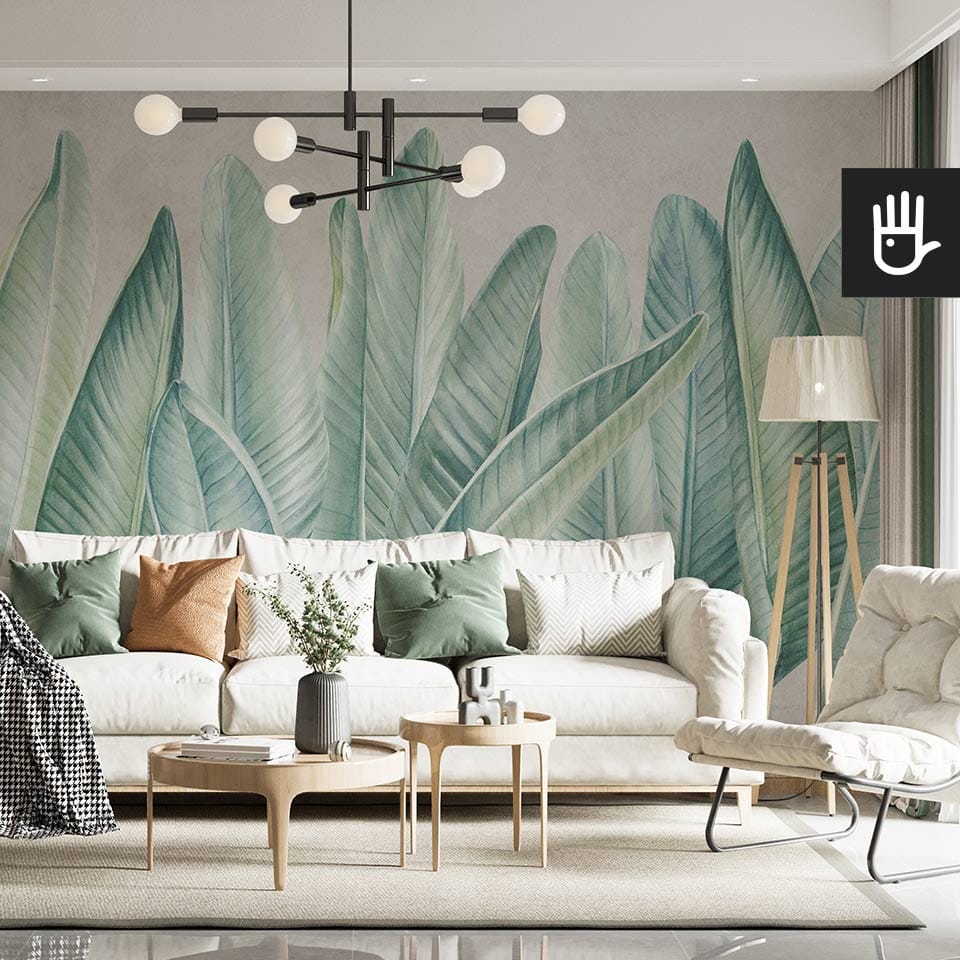 Nowoczesny salon boho z jasną kanapą na tle ściany z dekoracją ścienną, którą jest fototapeta Klasyczne zielone liście na betonowym tle w artystycznym klimacie
