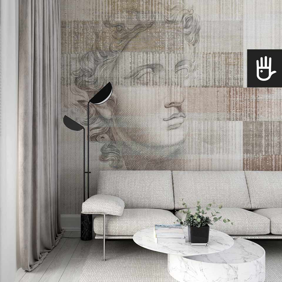 Stylowy salon z jasną kanapą i marmurowym stolikiem w otoczeniu pięknej fototapety Apollo z antycznym posągiem na na tle beżowo - brązowego dywanowego deseniu.
