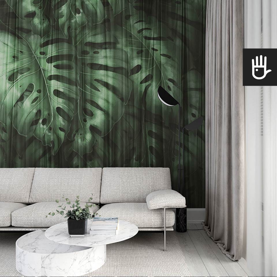 Nowoczesny salon we włoskim stylu z beżową kanapą na tle ciemnej fototapety Monstera z dużymi liśćmi egzotycznej rośliny w odcieniach zgniłej zieleni wyłaniających się zza delikatnej, prześwitującej zasłony.