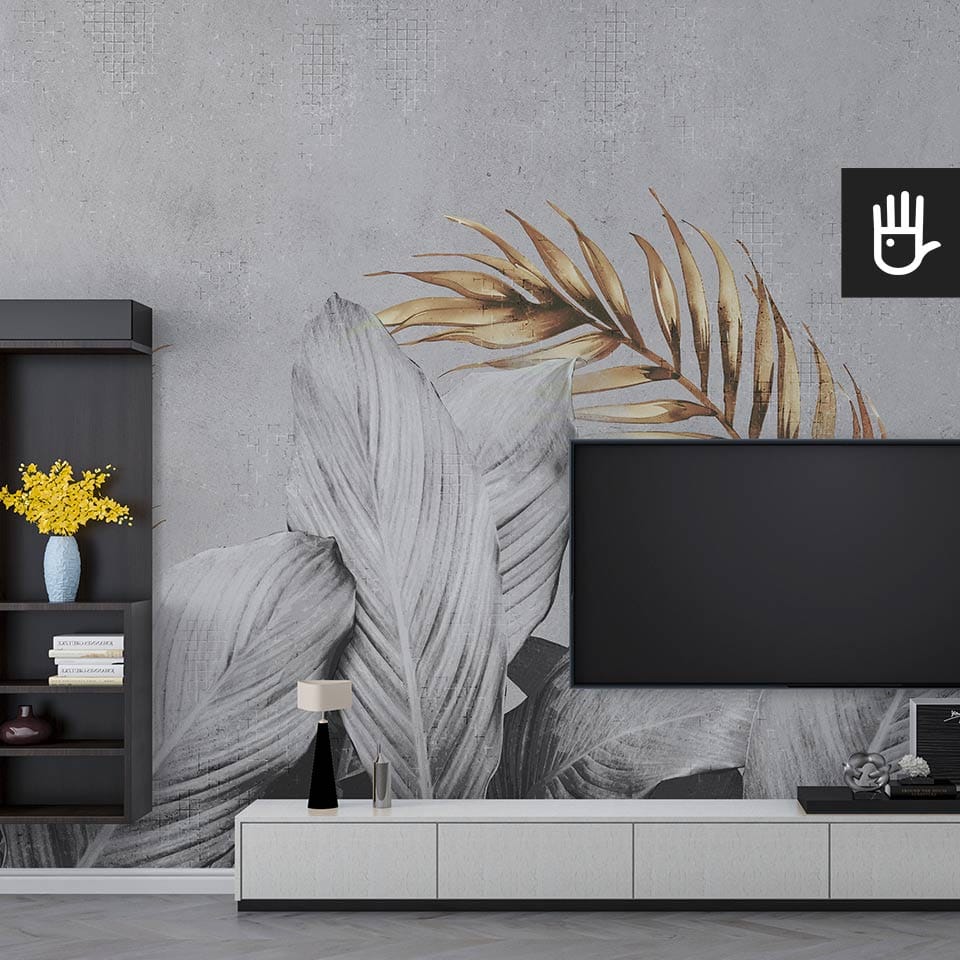 Nowoczesny salon urządzony w bieli i czerni z dużym telewizorem i stonowanymi dodatkami na tle fototapety w liście
