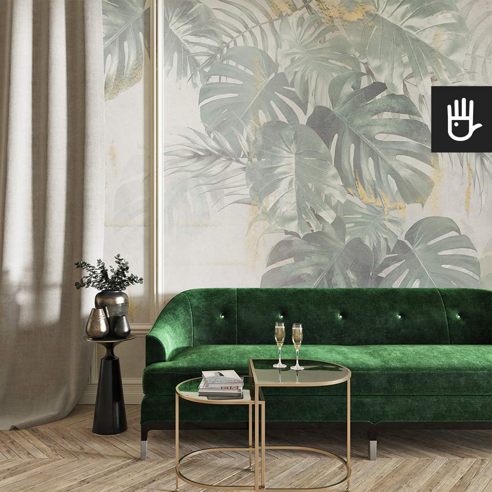 Klasyczny salon z zieloną kanapą i dekoracyjnym stolikiem kawowym na tle fototapety monstera w betonie