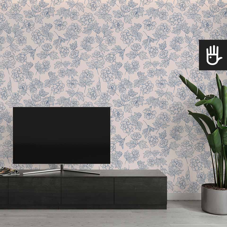 Nowoczesny salon z czarną szafką rtv i telewizorem obok ozdobnego kwiatka na tle tapety w niebieskie piwonie