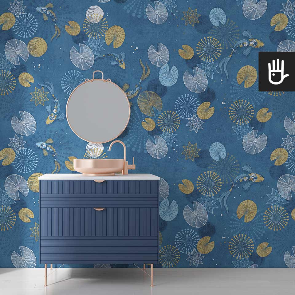 Przestronna łazienka z umywalką i oprawą lustra w kolorze złota i szafką w kolorze granatu z dekoracyjną tapetą w rybki i lilie wodne