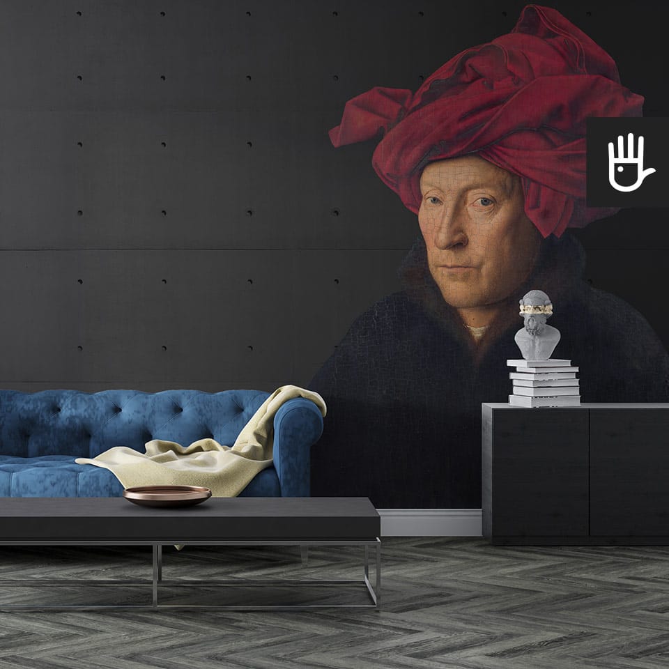 Klasyczny salon z granatową pikowaną kanapą i dekoracyjnym stolikiem kawowym, na tle fototapety z mężczyzną w turbanie
