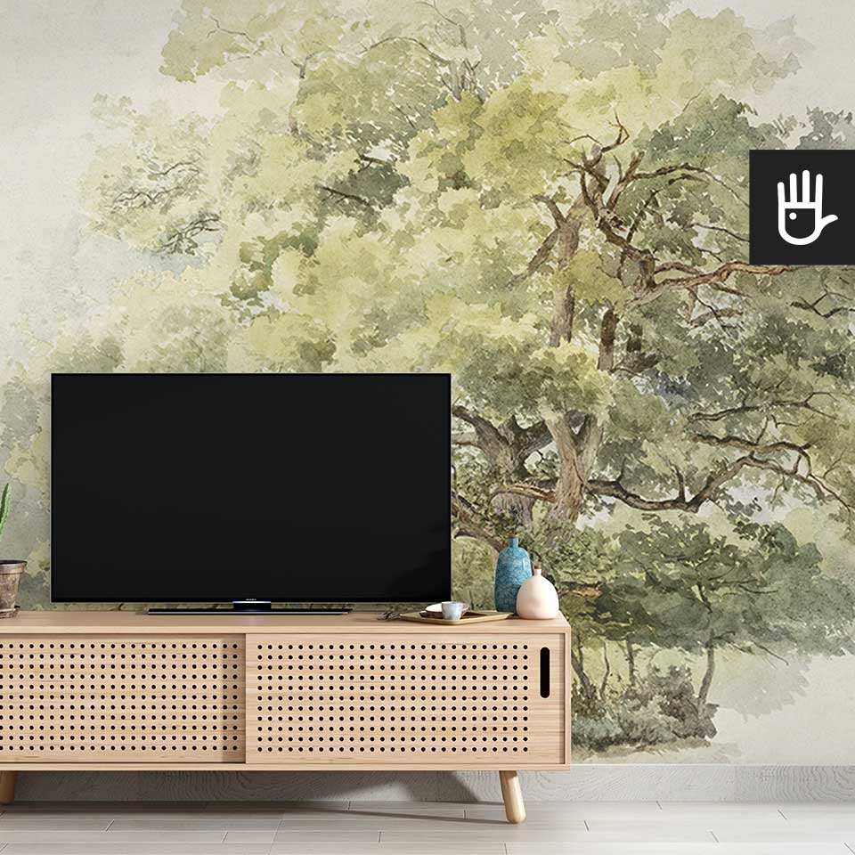 Drewniana szafka rtv w stylu boho z dekoracjami w różnych kolorach na tle fototapety z akwarelowym drzewem