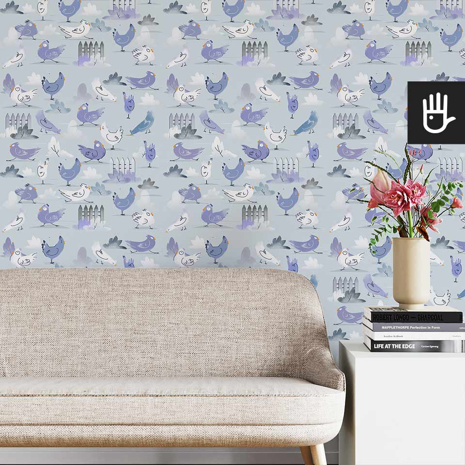 Jasny salon w stylu boho z beżową kanapą na tle tapety ze wzorem w niebieskie kurki