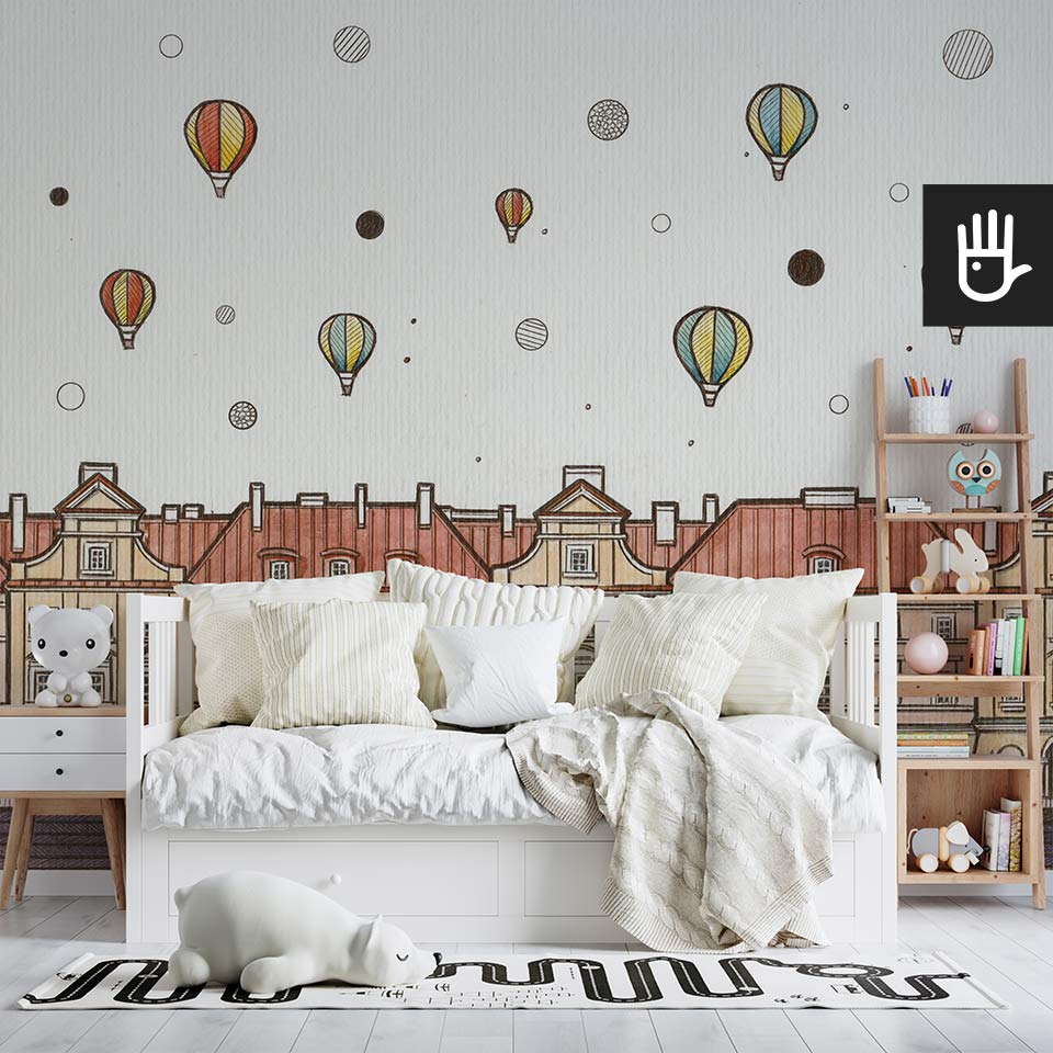 Przytulna sypialnia dziecięca z białym łóżkiem i drewnianym regałem na książki na tle fototapety w balony nad miastem