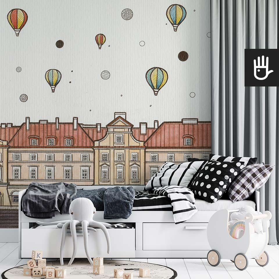 Przytulna sypialnia dziecięca z białym łóżkiem na tle fototapety w balony nad miastem