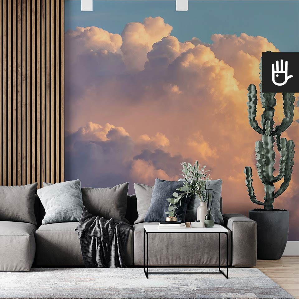Nowoczesny salon z dużą kanapą i dekoracyjnym kaktusem na tle ściany z lamelami i fototapetą w chmury