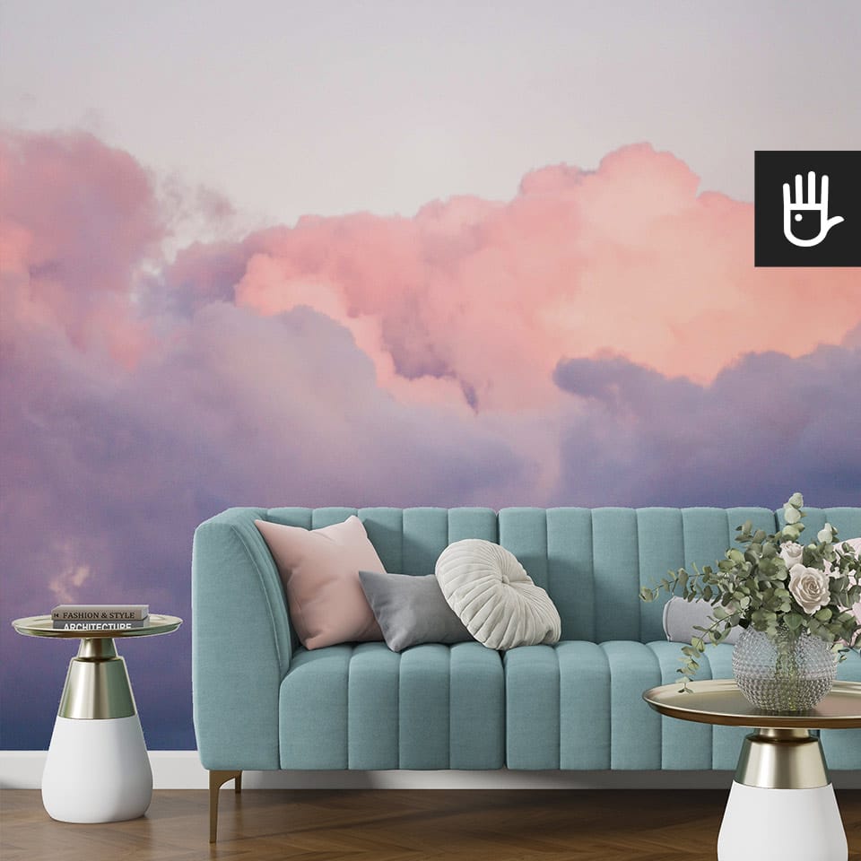 Salon w stylu glamour z turkusową kanapą i pastelowymi poduszkami i dodatkami w kolorze złota na tle fototapety różowe obłoki