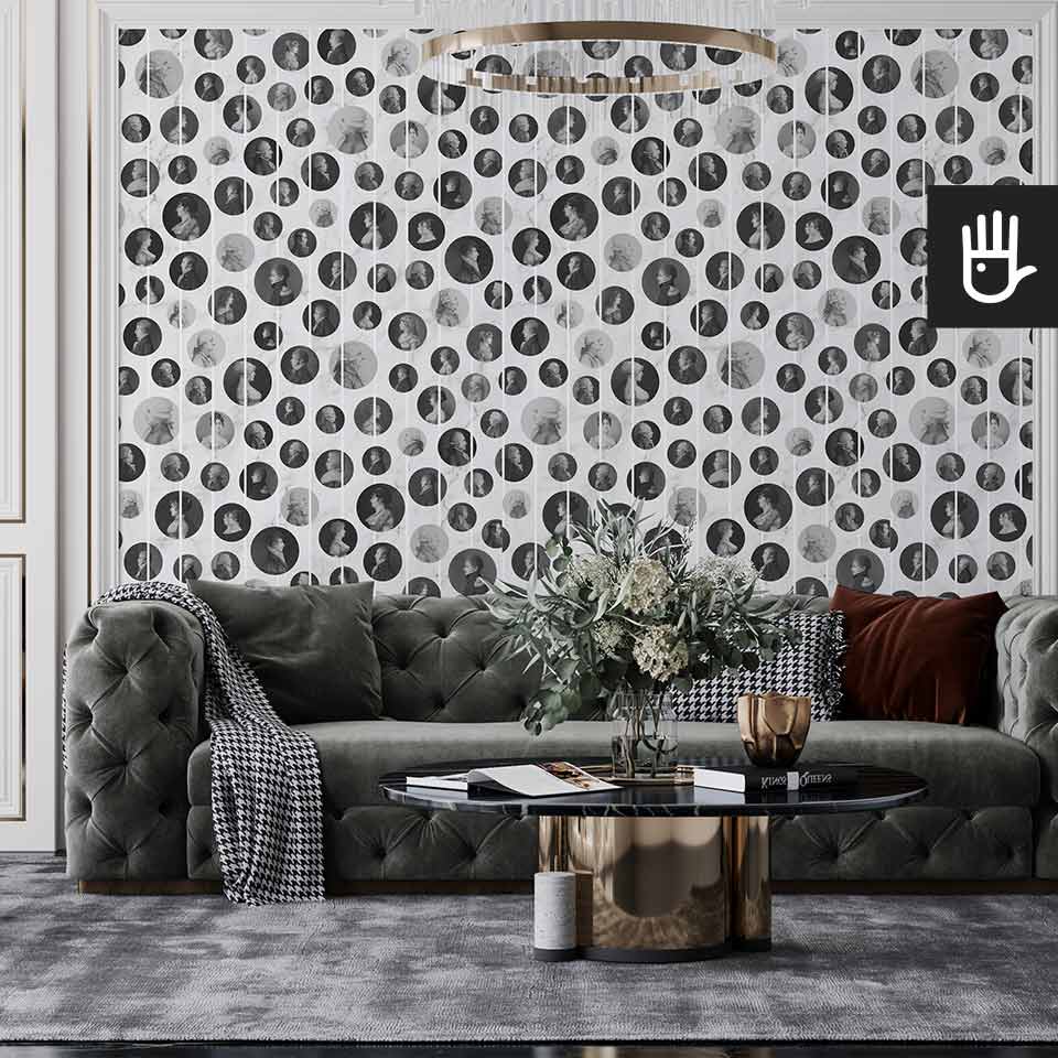 Klasyczny salon z szara pikowaną kanapą, urządzony w stylu glamour z wieloma złotymi dodatkami na tle tapety z podobiznami arystokratów