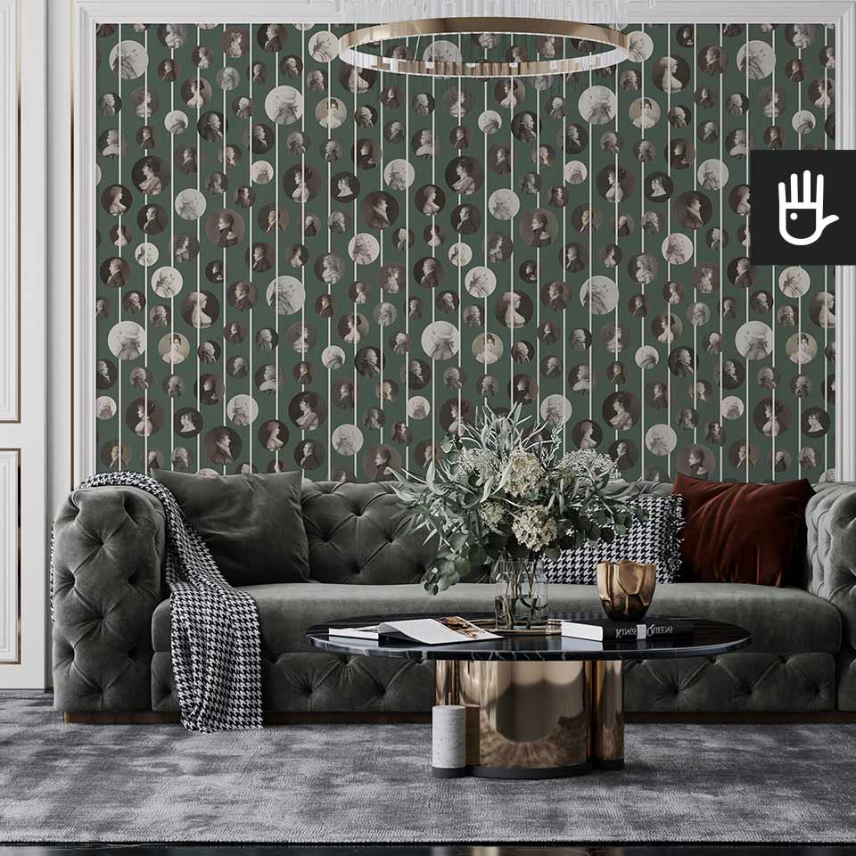 Klasyczny salon z szara pikowaną kanapą, urządzony w stylu glamour z wieloma złotymi dodatkami na tle tapety z podobiznami arystokratów
