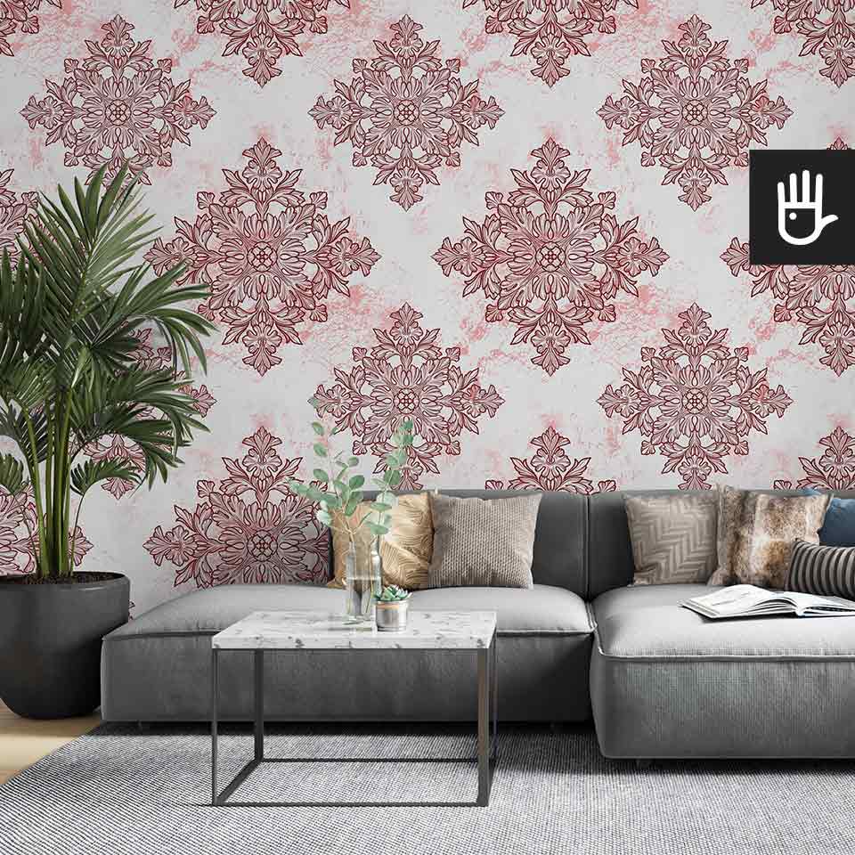 Jasny salon z szarą kanapą i ozdobnym kwiatem palmą ze stolikiem z imitacji marmuru na tle tapety w geometryczny wzór