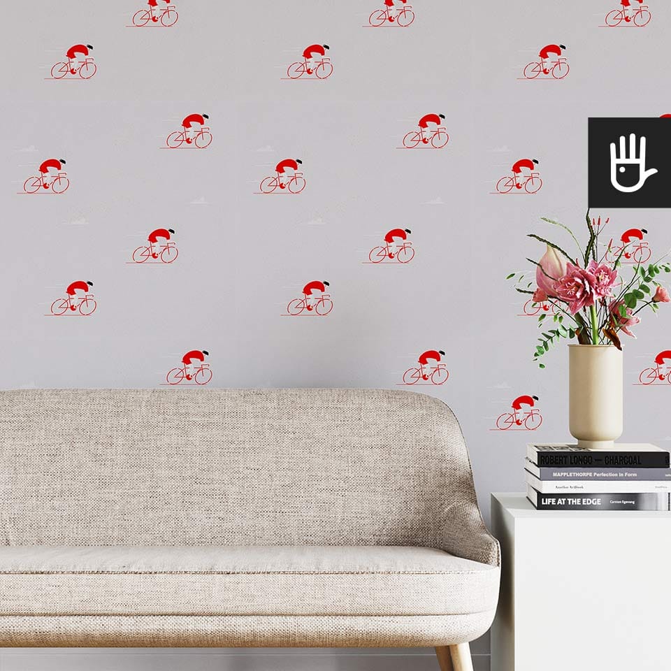 Jasny salon w stylu boho z beżową kanapą na tle tapety ze wzorem w czerwonych kolarzy