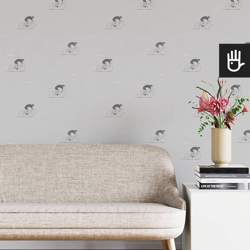 Jasny salon w stylu boho z beżową kanapą na tle tapety ze wzorem w szarych kolarzy
