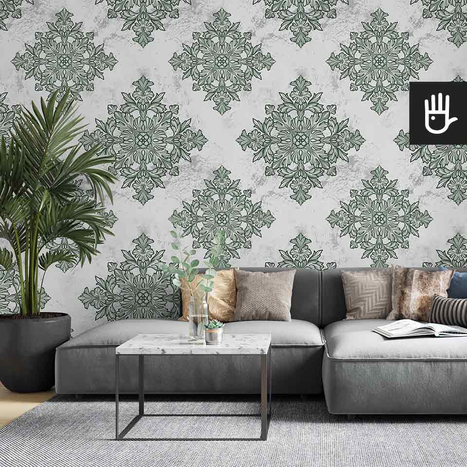 Jasny salon z szarą kanapą i ozdobnym kwiatem palmą ze stolikiem z imitacji marmuru na tle tapety w geometryczny wzór