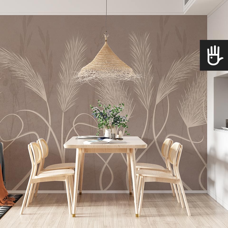 Jadalnia urządzona w stylu boho z naturalnymi meblami w jasnych kolorach i ozdobną lampą wiszącą na tle fototapety w wysokie trawy pampasowe