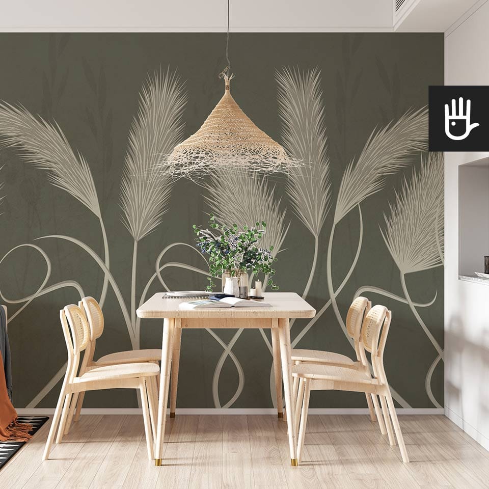 Jadalnia urządzona w stylu boho z naturalnymi meblami w jasnych kolorach i ozdobną lampą wiszącą na tle fototapety w wysokie trawy pampasowe