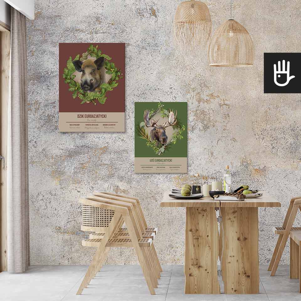 Jadalnia w stylu boho z drewnianym stołem i krzesłami pod dekoracyjnymi lampami wiszącymi z wikliny, na tle obrazów z leśnymi zwierzętami