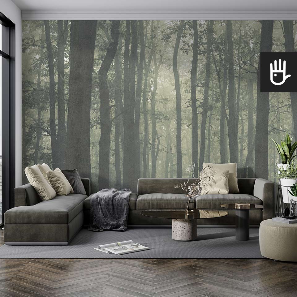 Klasyczny salon z dużą szarą kanapą i dekoracyjnymi stolikami kawowymi na tle fototapety z magicznym zielonym lasem