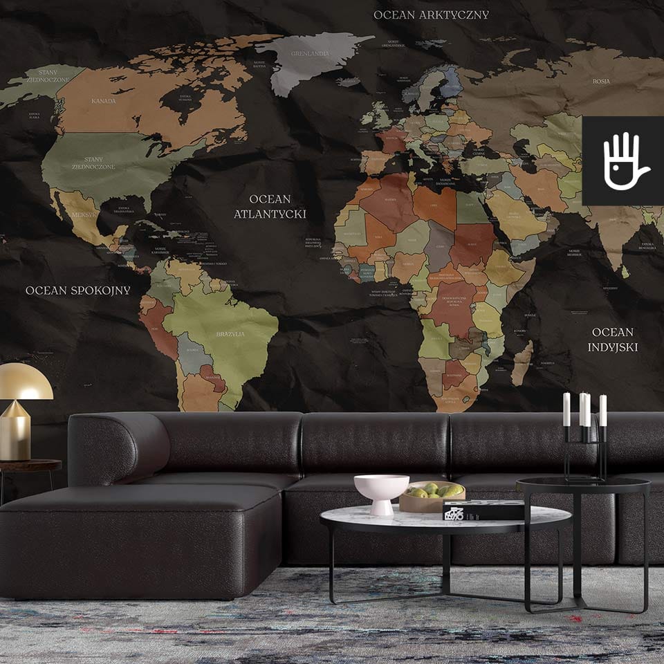 Nowoczesny salon urządzony w czarnych meblach z dodatkiem imitacji marmuru na tle czarnej fototapety z mapą świata
