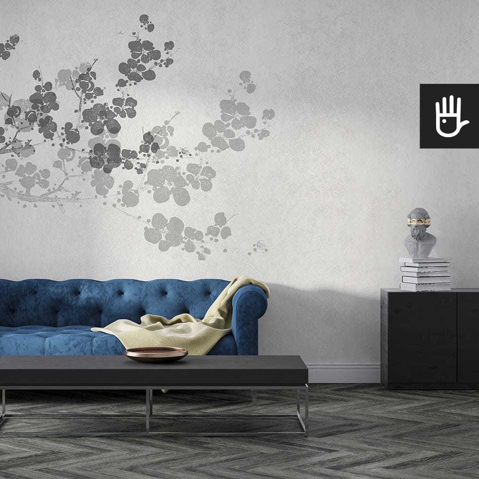 Przytulny salon w stylu glamour z granatową kanapą i czarnymi meblami z dekoracyjną tapetą kwiaty sakury