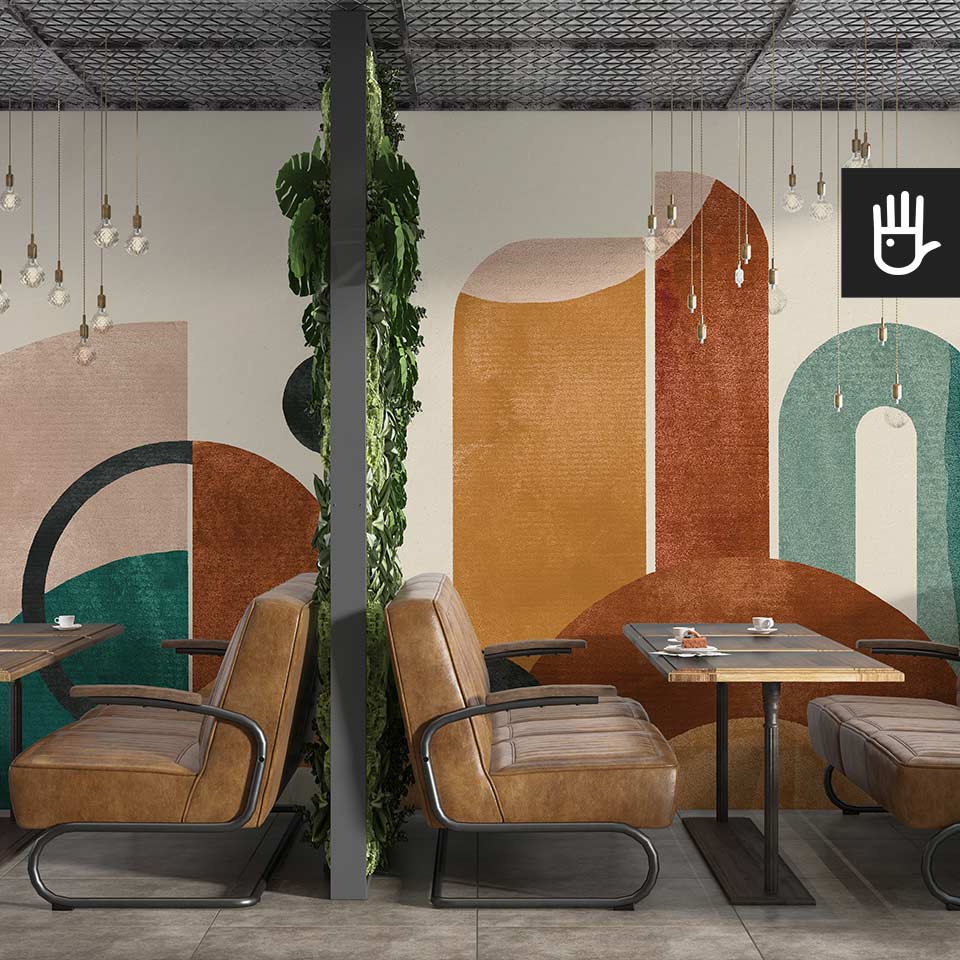 Restauracja w stylu retro ze skórzanymi kanapami i drewnianymi stolikami na tle dekoracyjnej fototapety w kolorowe abstrakcyjne wzory