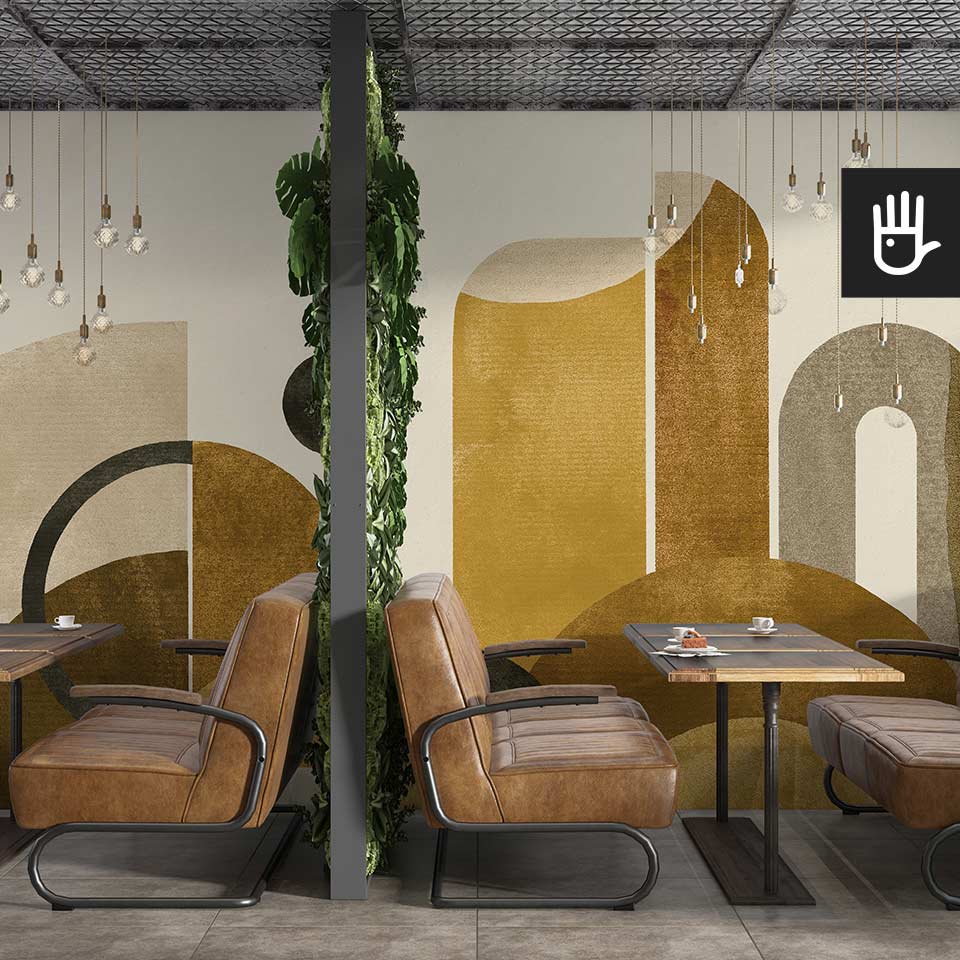 Restauracja w stylu retro ze skórzanymi kanapami i drewnianymi stolikami na tle dekoracyjnej fototapety w złote abstrakcyjne wzory