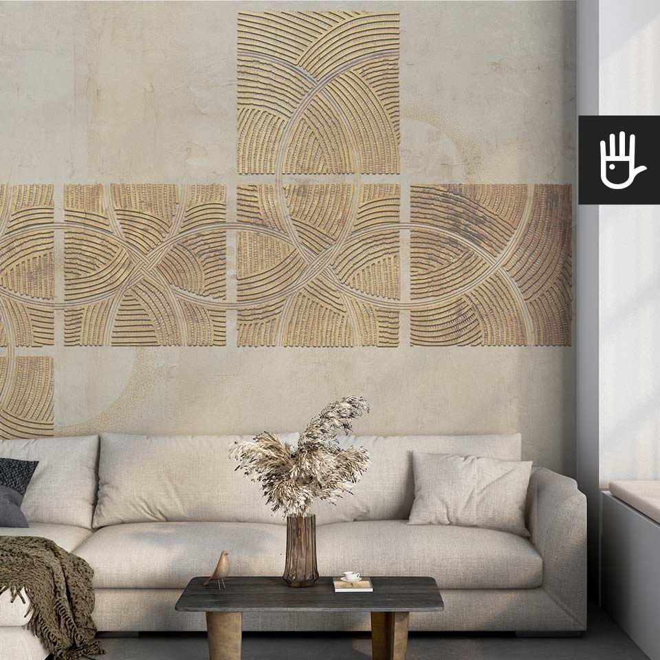 Jasny przytulny salon z materiałową kanapą na tle fototapety złoto na betonie i udekorowany dodatkami w stylu boho