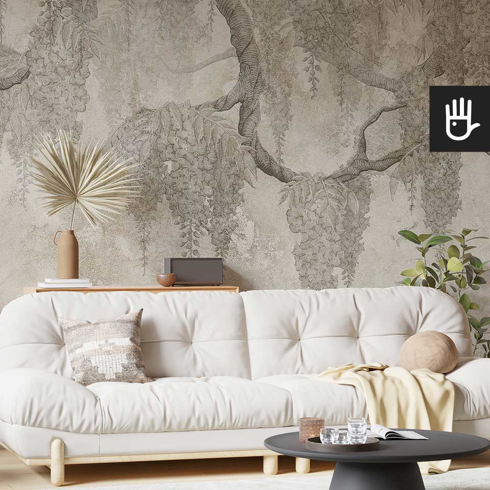 Przytulny salon z dużą białą kanapą z dekoracjami w stylu boho i fototapetą z beżowymi wisteriami